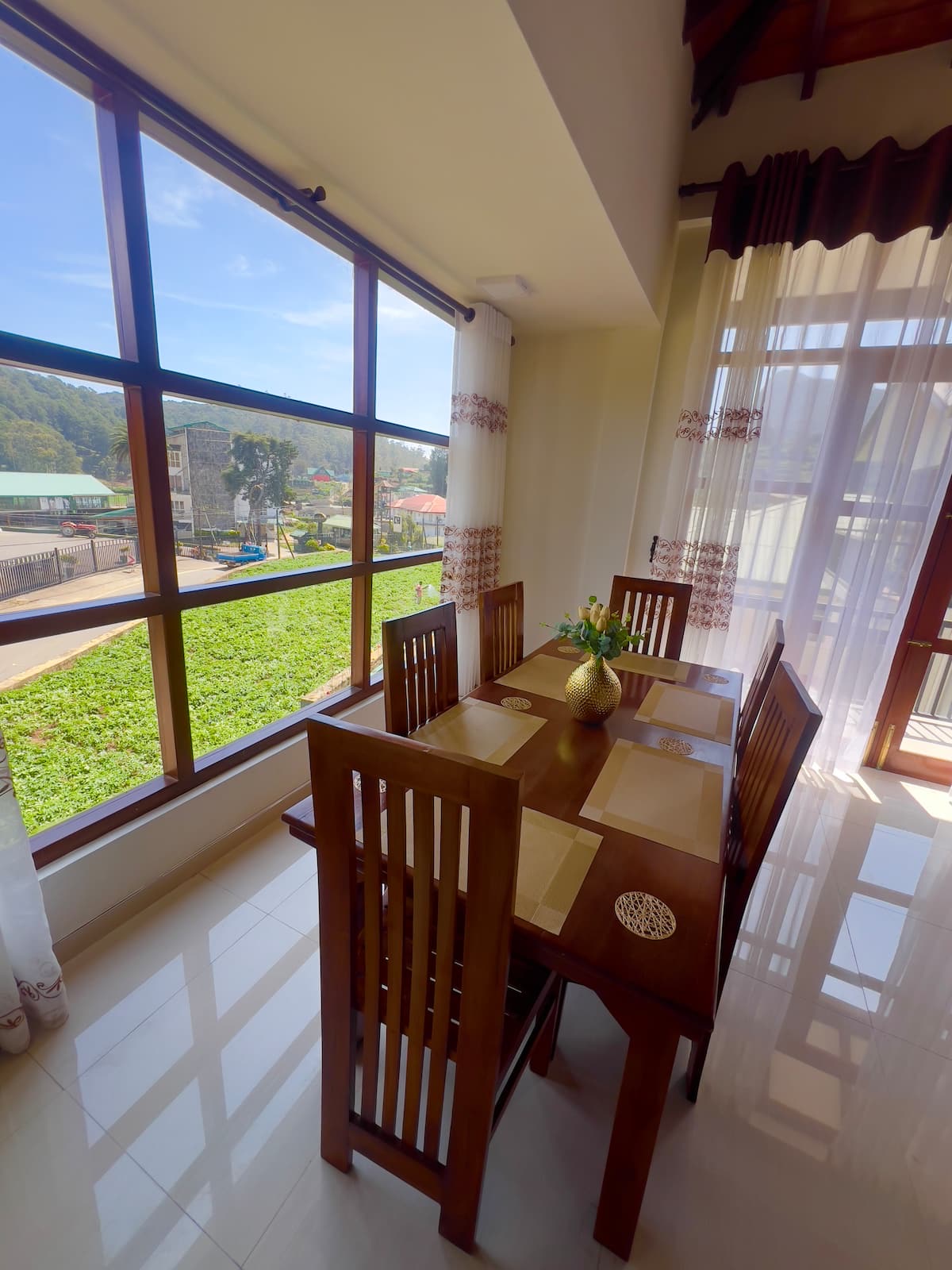 Dining table beside large windows overlooking the hills